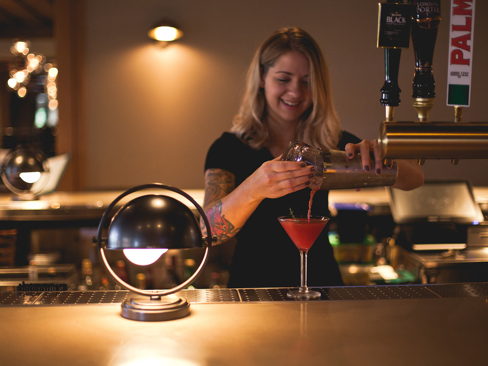 Bartender woman mixing cocktail at the bar at The Harbor Grand Hotel
