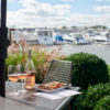 Outdoor dining with a bottle of rosé wine and bruschetta, with a view of the New Buffalo harbor in the background