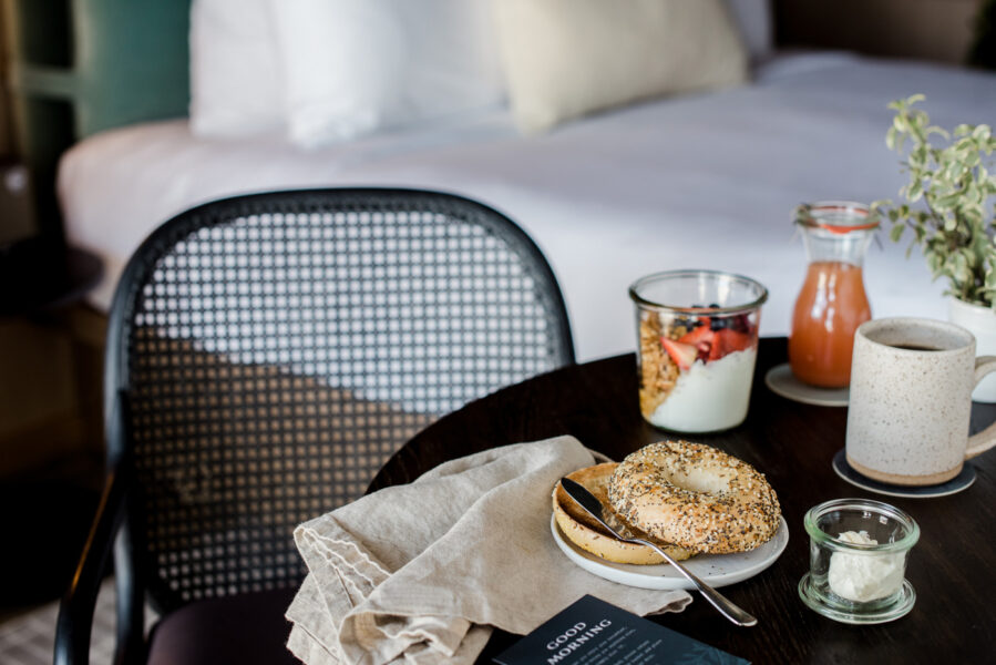 Breakfast Basket Served Breakfast scene with everything bagel, fruit, granola and yogurt in a waterfront guestroom at The Harbor Grand Hotel in New Buffalo, Michigan