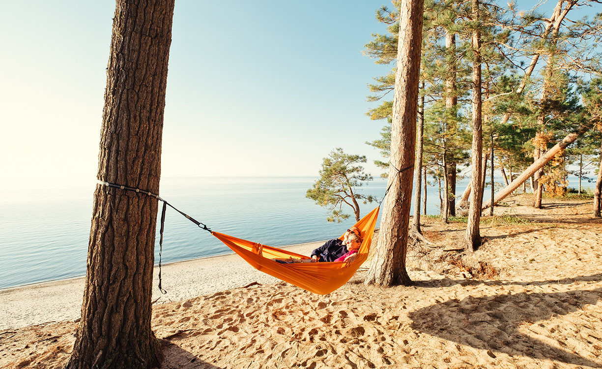 Couple on beach in hammock a couple in a hammock relaxing by the sandy shore of Lake Michigan