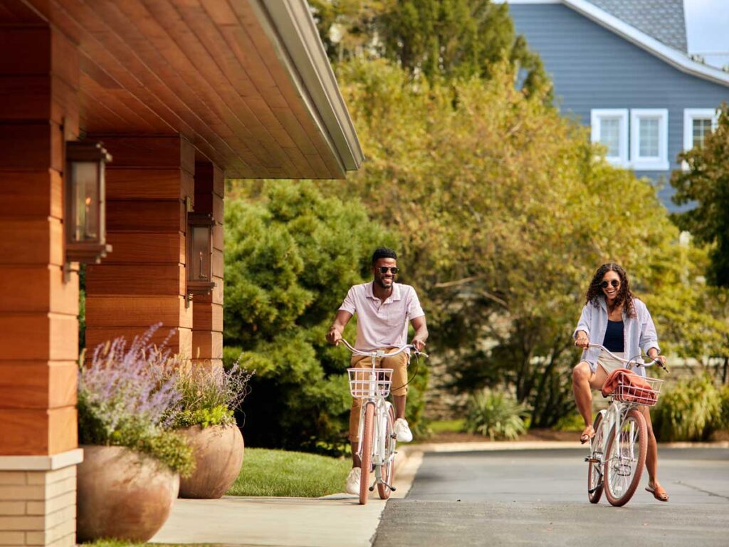 A man and woman smiling while riding bikes