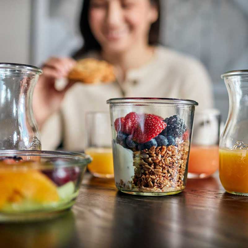 Breakfast Basket Items Breakfast at table with fruit and granola bowl and fresh juices
